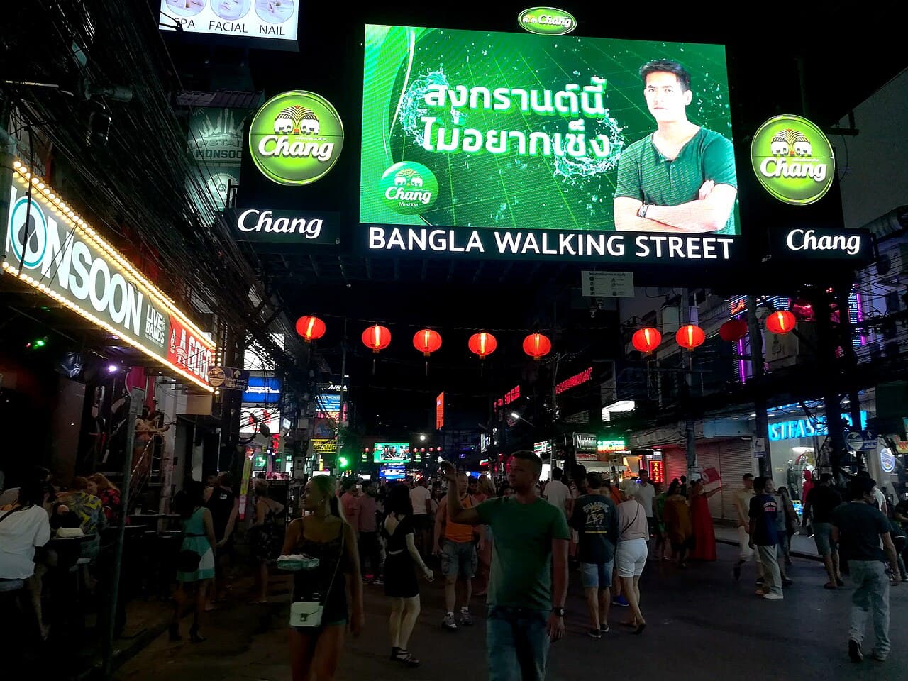 Illuminated Bangla Walking Street entrance, red lanterns and pedestrians in Patong, Phuket at night